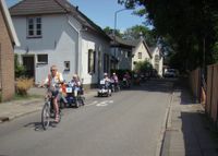 In de buurt van de kerk in Kerk-Avezaath vormt de schare deelnemers aan de toertocht van Flipje op wielen een soort trein